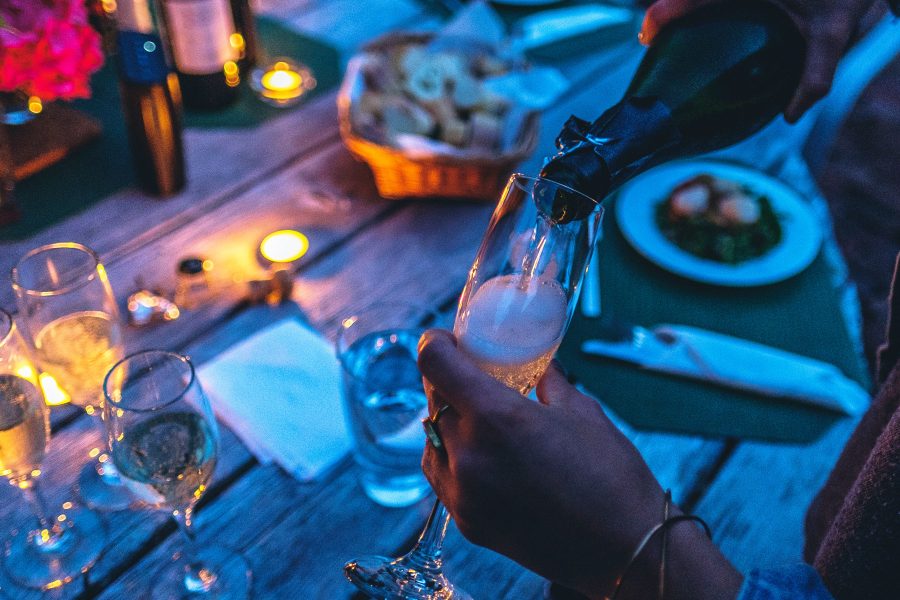 Woman pouring champagne into a glass at dusk